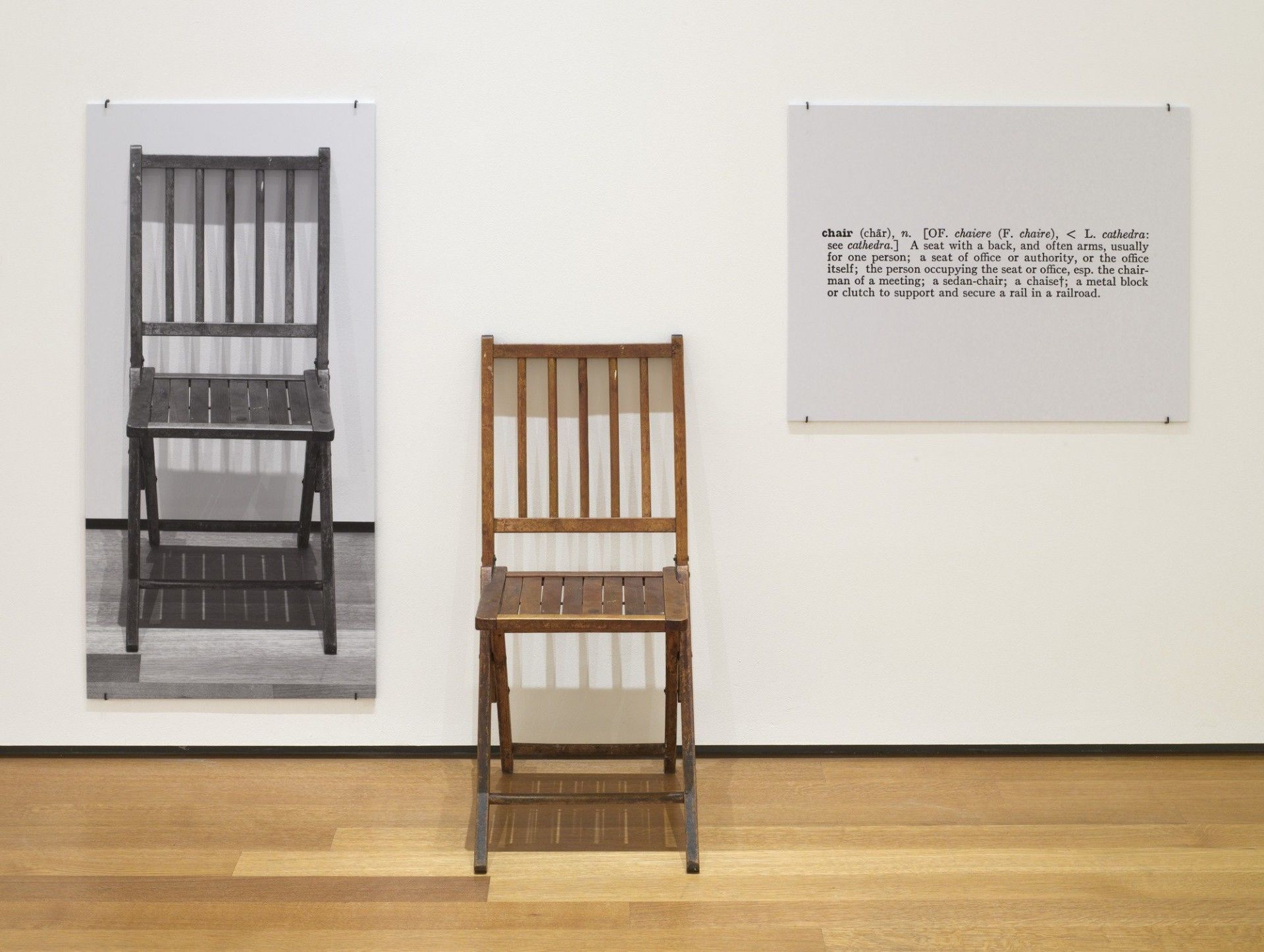 6. Campione di arte contemporanea di Joseph Kosuth, One and Three Chairs, 1965. Sedia pieghevole in legno, fotografia montata di una sedia e ingrandimento fotografico montato della definizione di 